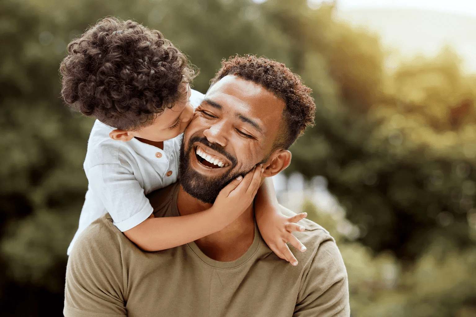 Child kissing father outdoors