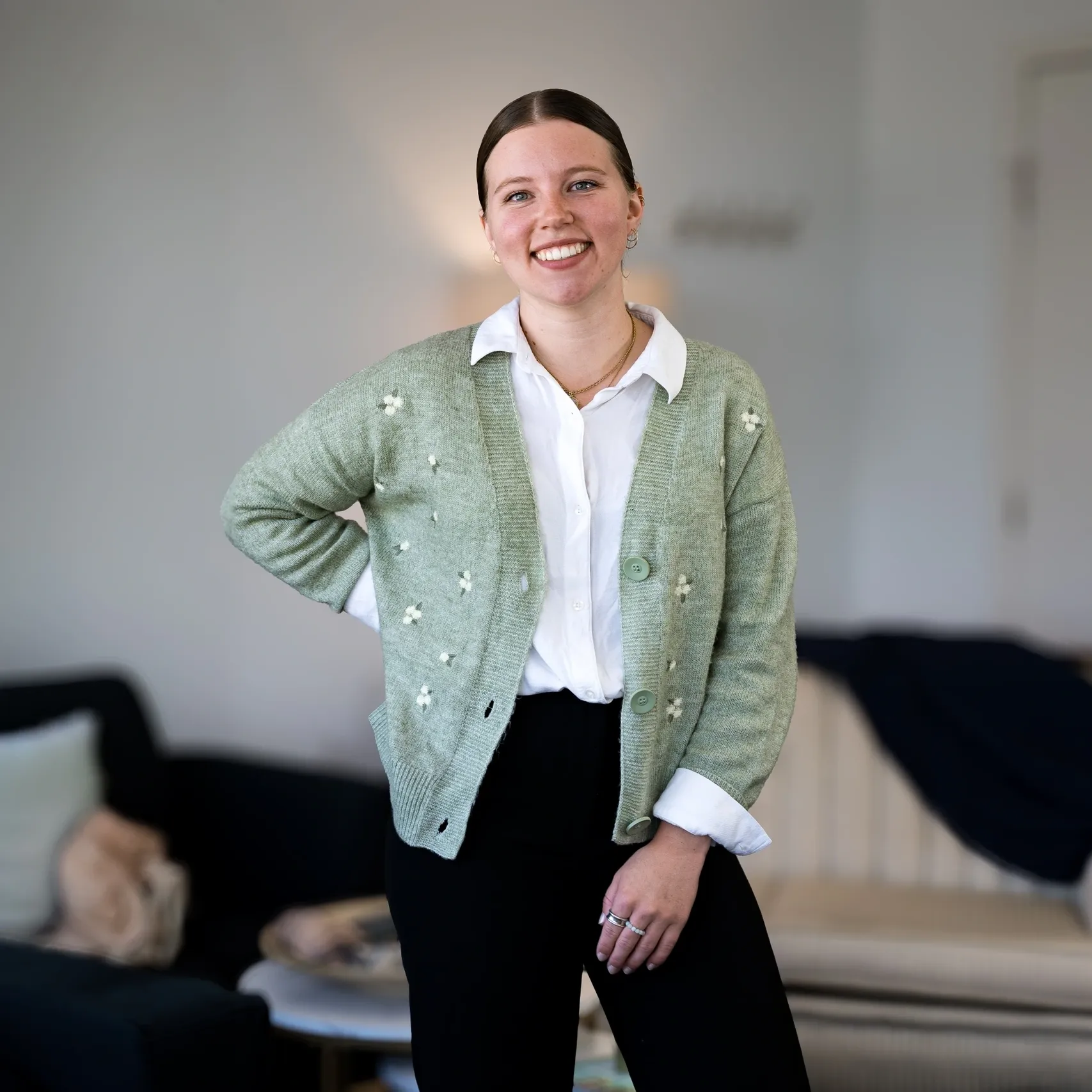 Smiling individual standing with hand on hip