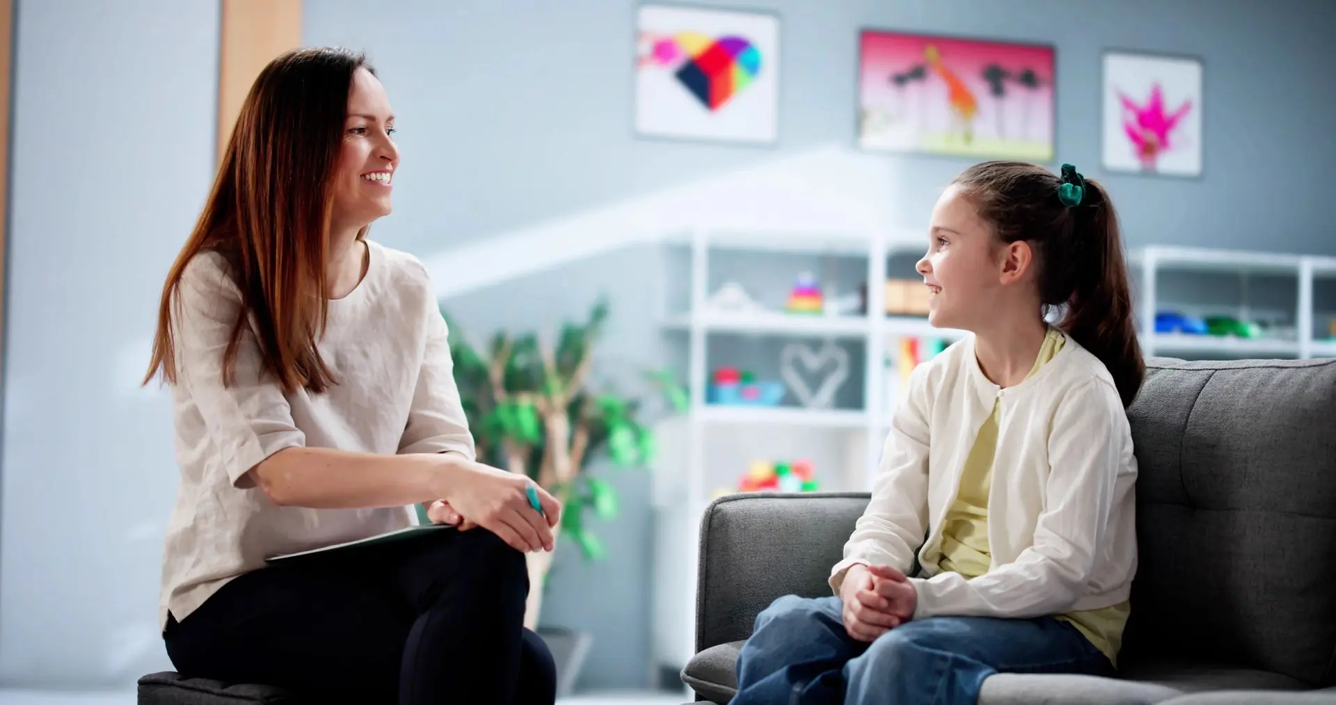 Woman and girl talking on a couch