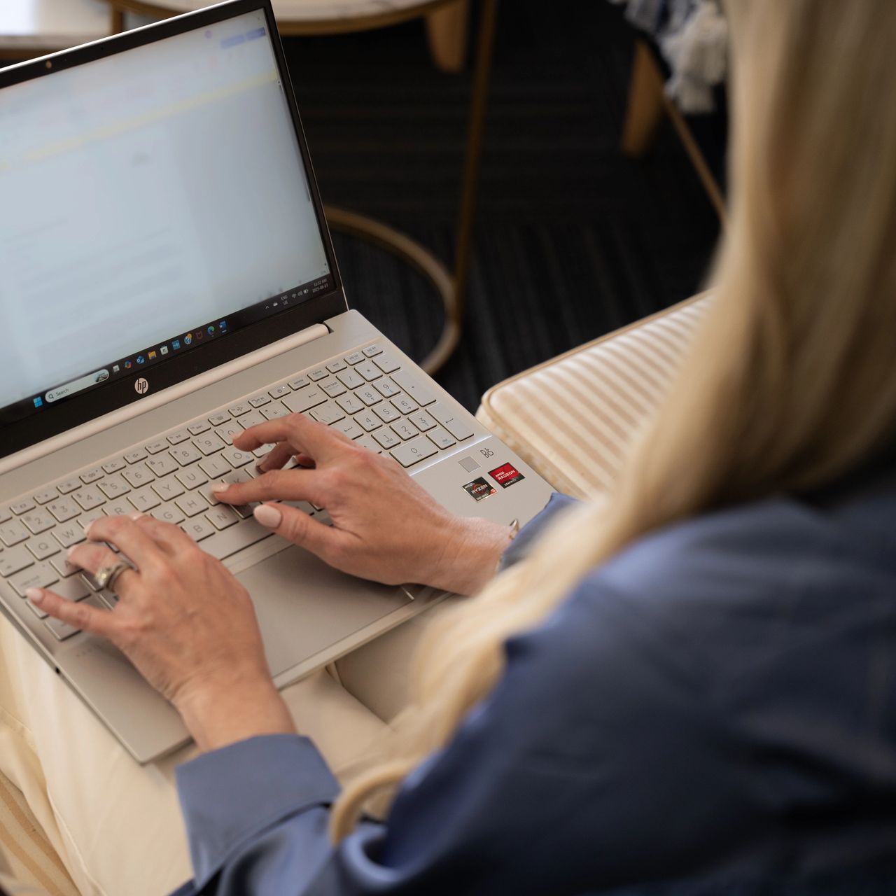 Person typing on a laptop at a desk with a notebook nearby.