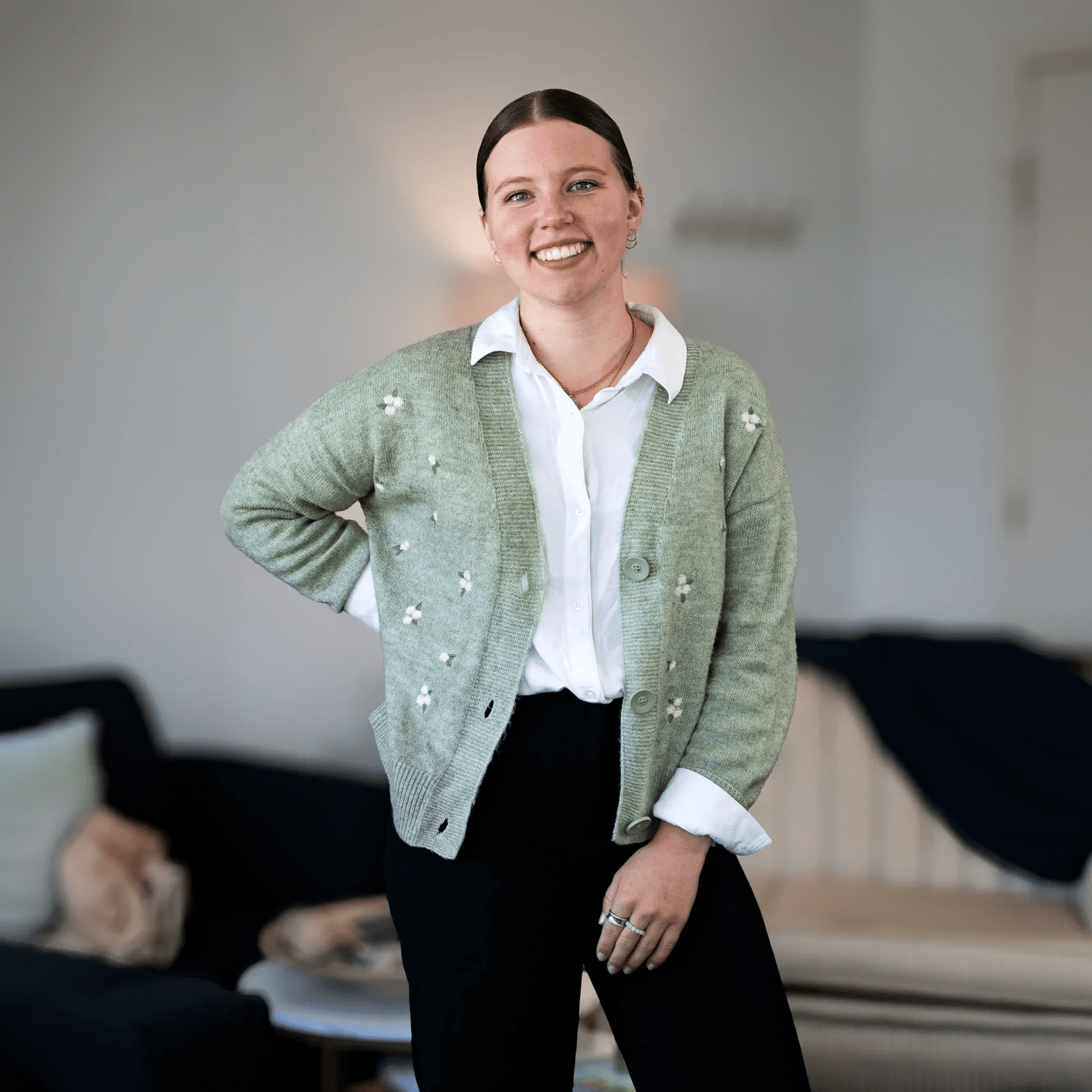 Smiling individual standing with hand on hip